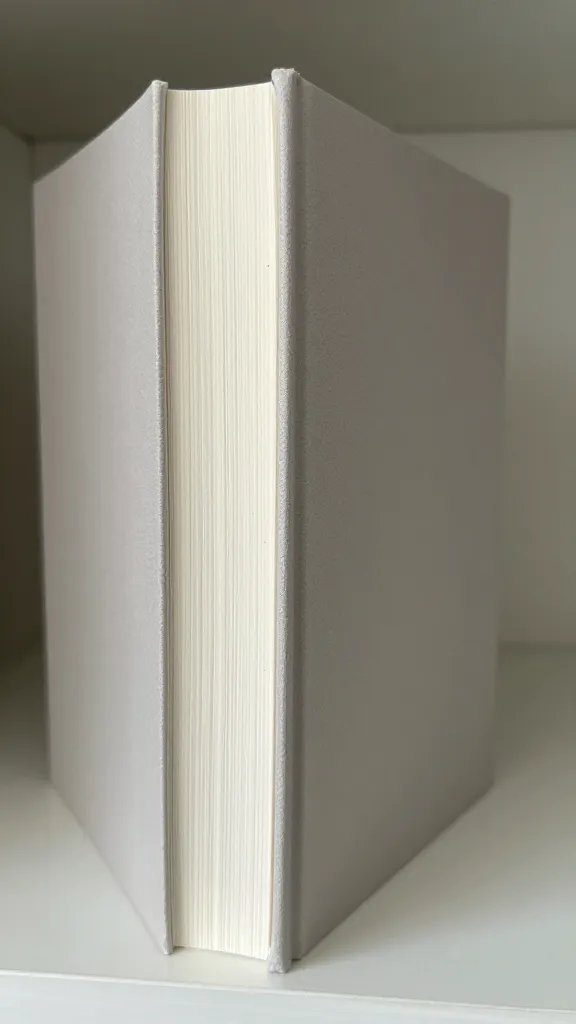 closeup of a single hardcover book with a neutral spine on open shelf