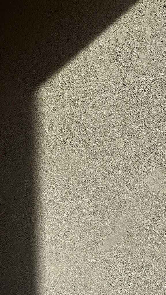 Closeup of textured Venetian plaster wall surface, dramatic light