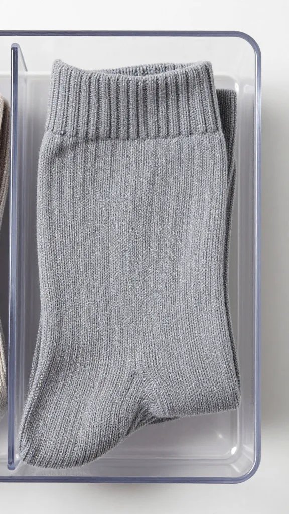 Closeup of a folded sock in a transparent divider tray