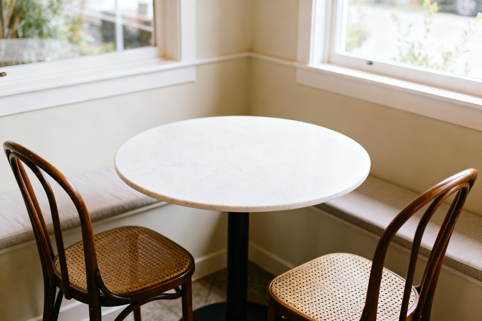 A compact round dining table with two chairs in a cozy nook