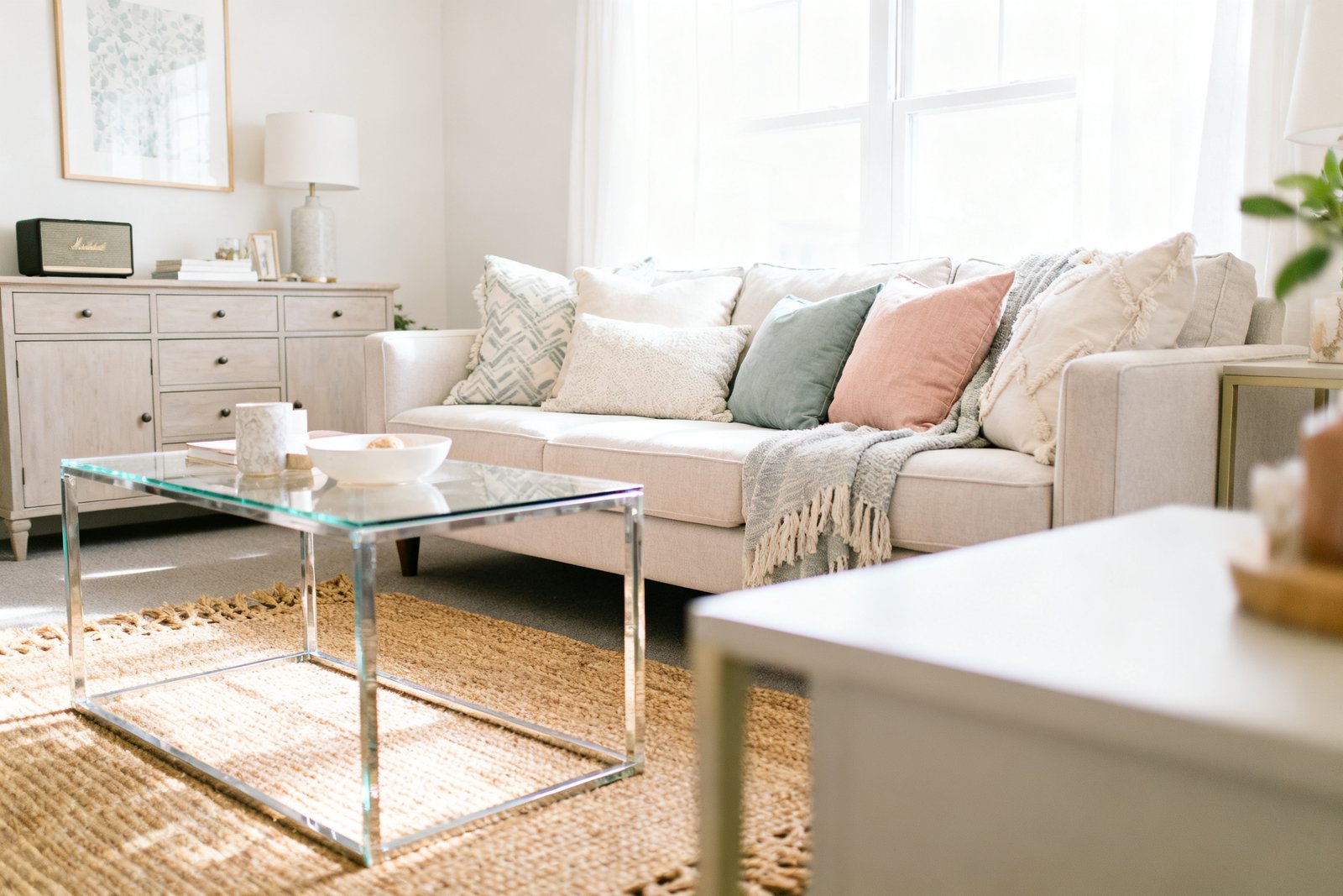 A tidy, welcoming living room that looks guest-ready with fluffed pillows and clear surfaces, bright