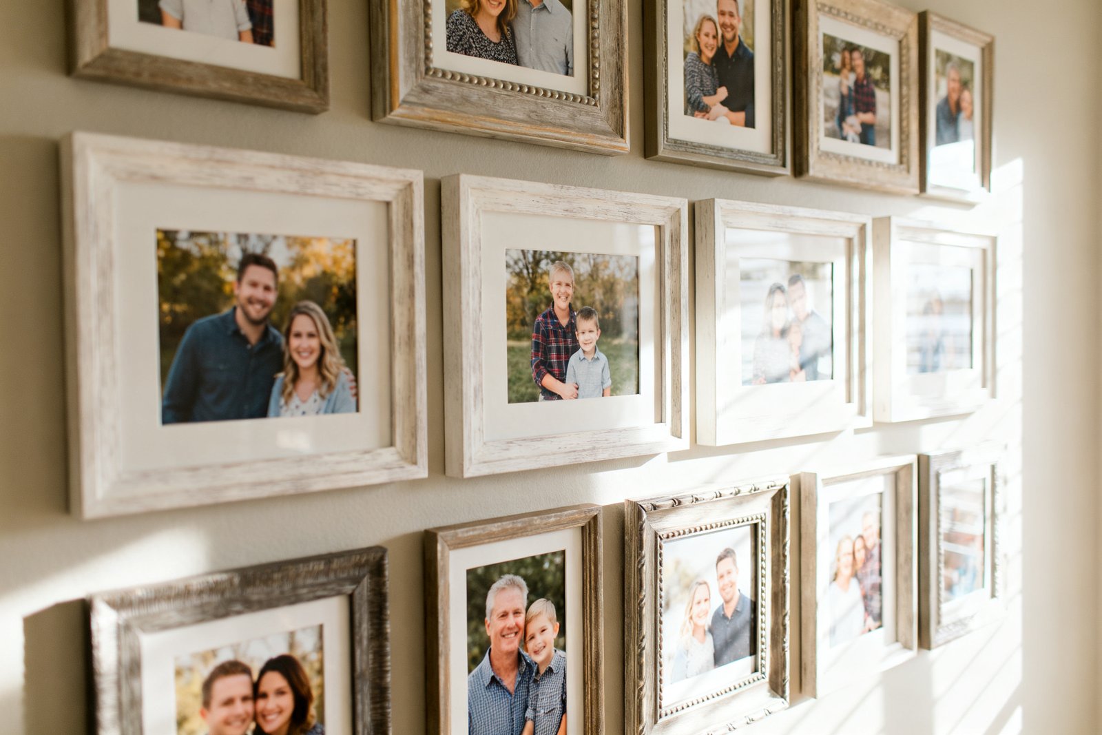 A neat grid of framed family photos on a wall